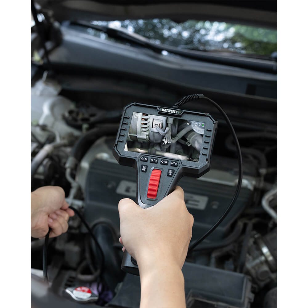 Mechanic using an automotive borescope to inspect a car engine compartment